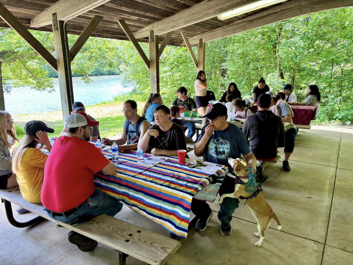 A group of people sitting at a picnic shelter