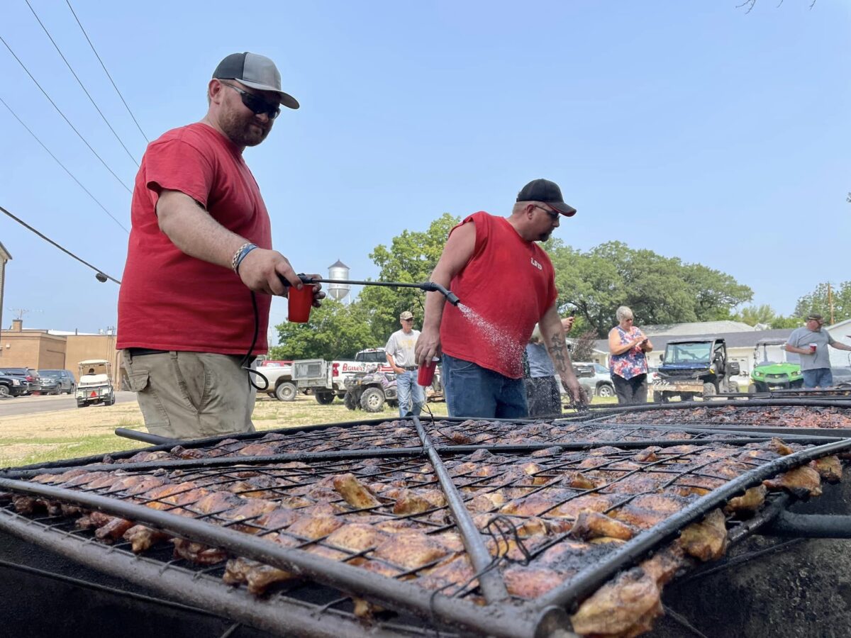Two men grilling chicken
