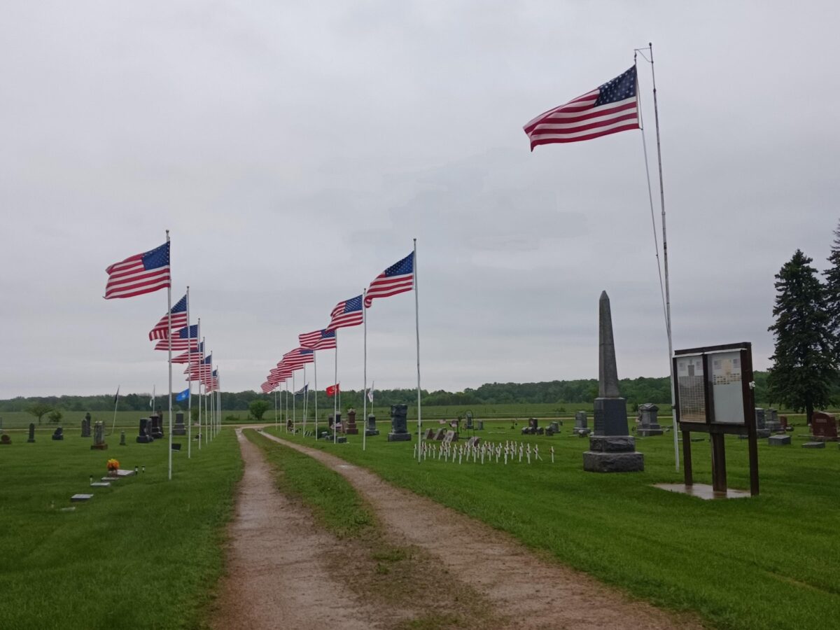 A row of American flags at the LeRoy Cemetery